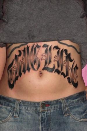 Thug Life Lettering Tattoo On Girl Stomach