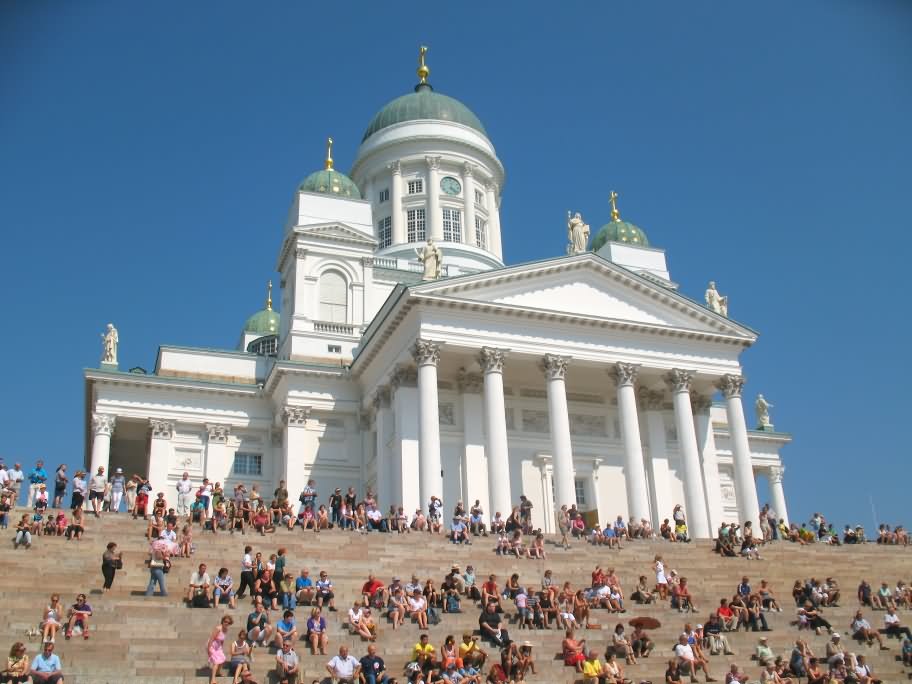 Tourists Enjoying Sunny Day Sitting In Front Of Helsinki Cathedral