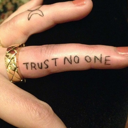 Trust No One Lettering Tattoo On Girl Finger