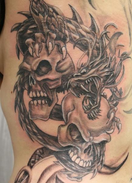 Two Gothic Skulls With Dragon Tattoo Design For Side Rib