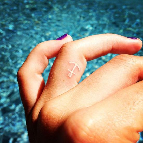 White Ink Anchor Tattoo On Girl Finger