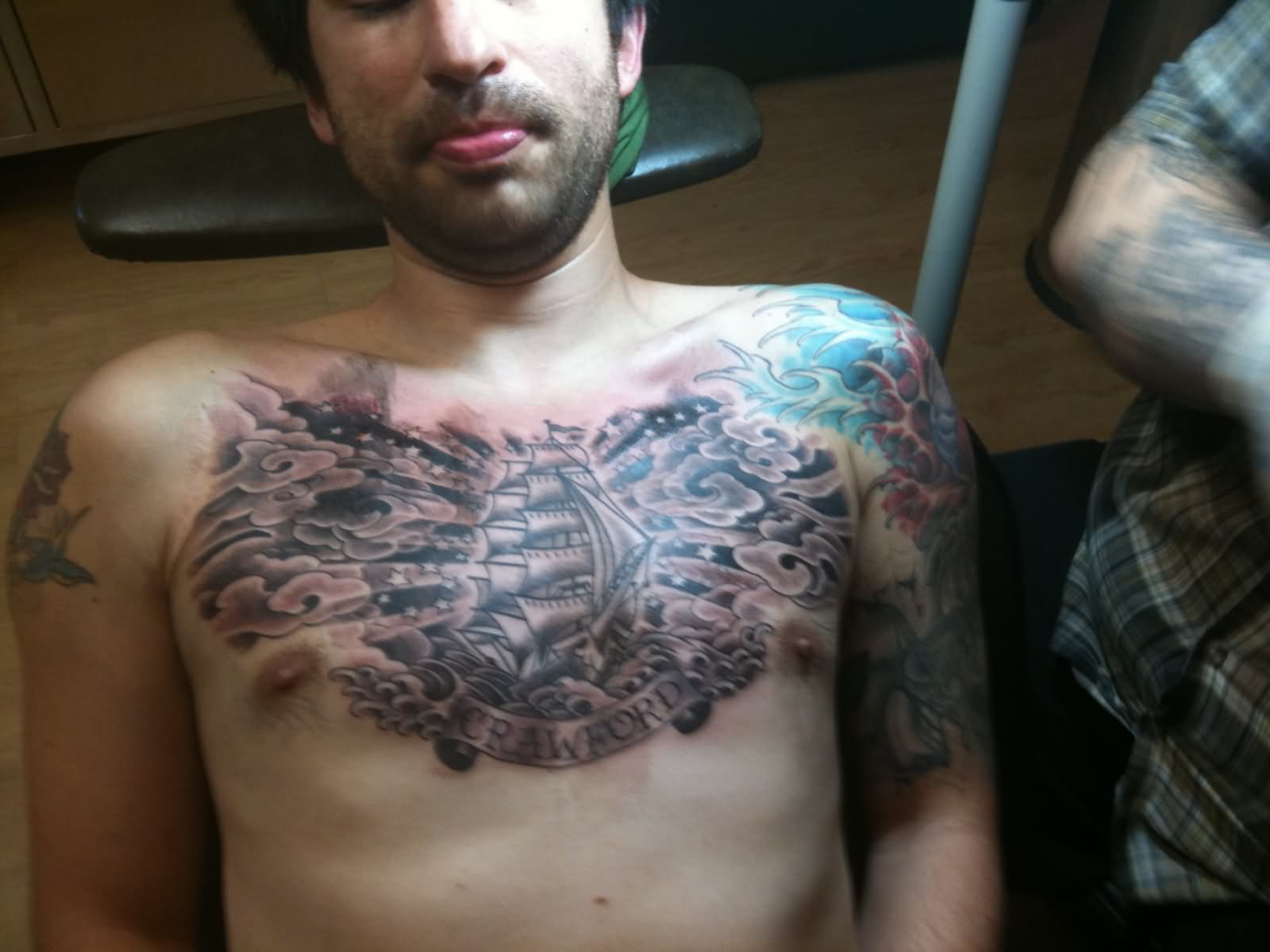 Black Ink Ship With Banner And Clouds Tattoo On Man Chest