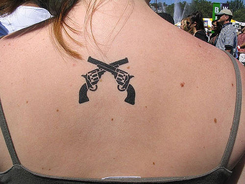 Black Revolver Tattoos On Upper Back