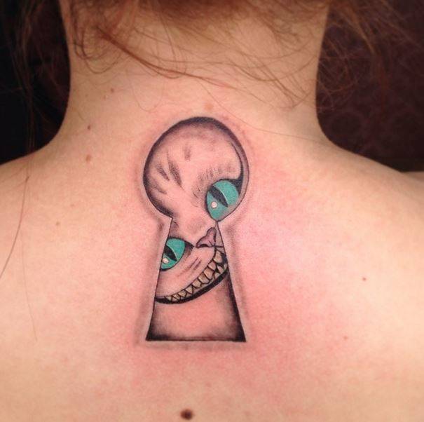 Cheshire Cat Face In Lock Key Tattoo On Upper Back