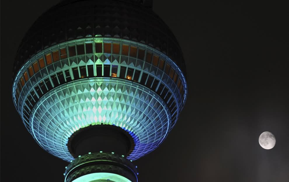 Closeup Of The Dome Of Fernsehturm Tower at Night With Full Moon