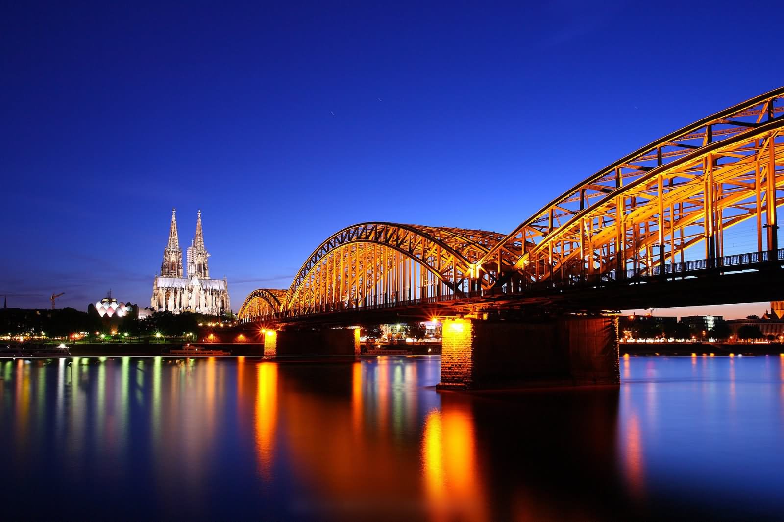 Cologne Cathedral And Hohenzollern Bridge At Twilight During Night