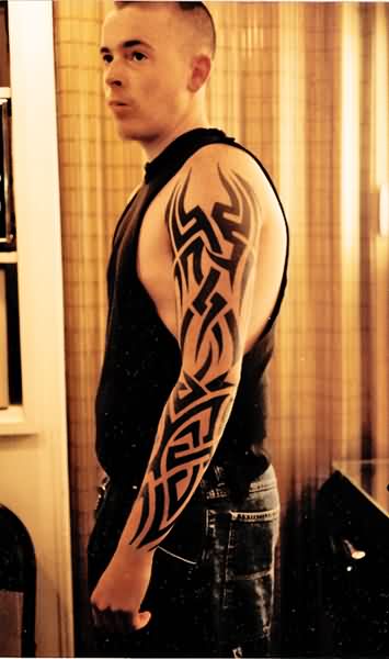 Fantastic Black Tribal Design Tattoo On Man Left Full Sleeve
