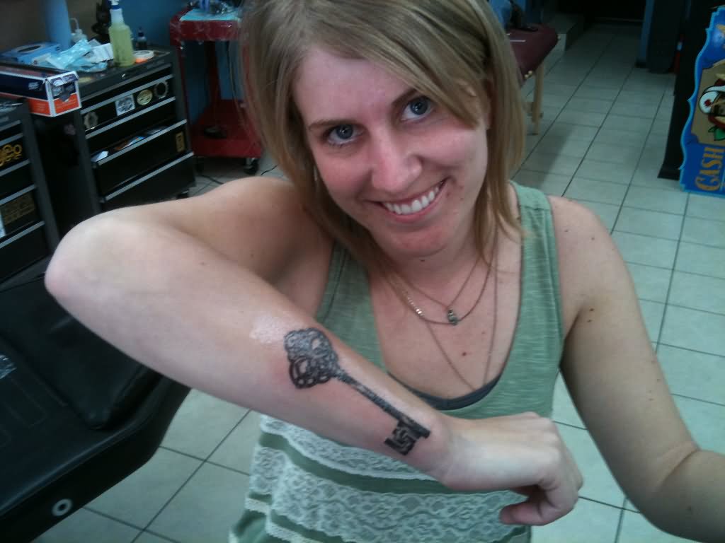Girl Showing Her Skeleton Key Tattoo On Right Arm