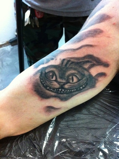Grey Ink Cheshire Cat Tattoo On Arm