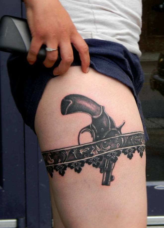 Grey Ink Dark Ink Garter Revolver Tattoo On Thigh