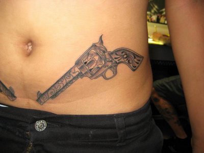 Grey Ink Revolver Tattoo On Left Hip