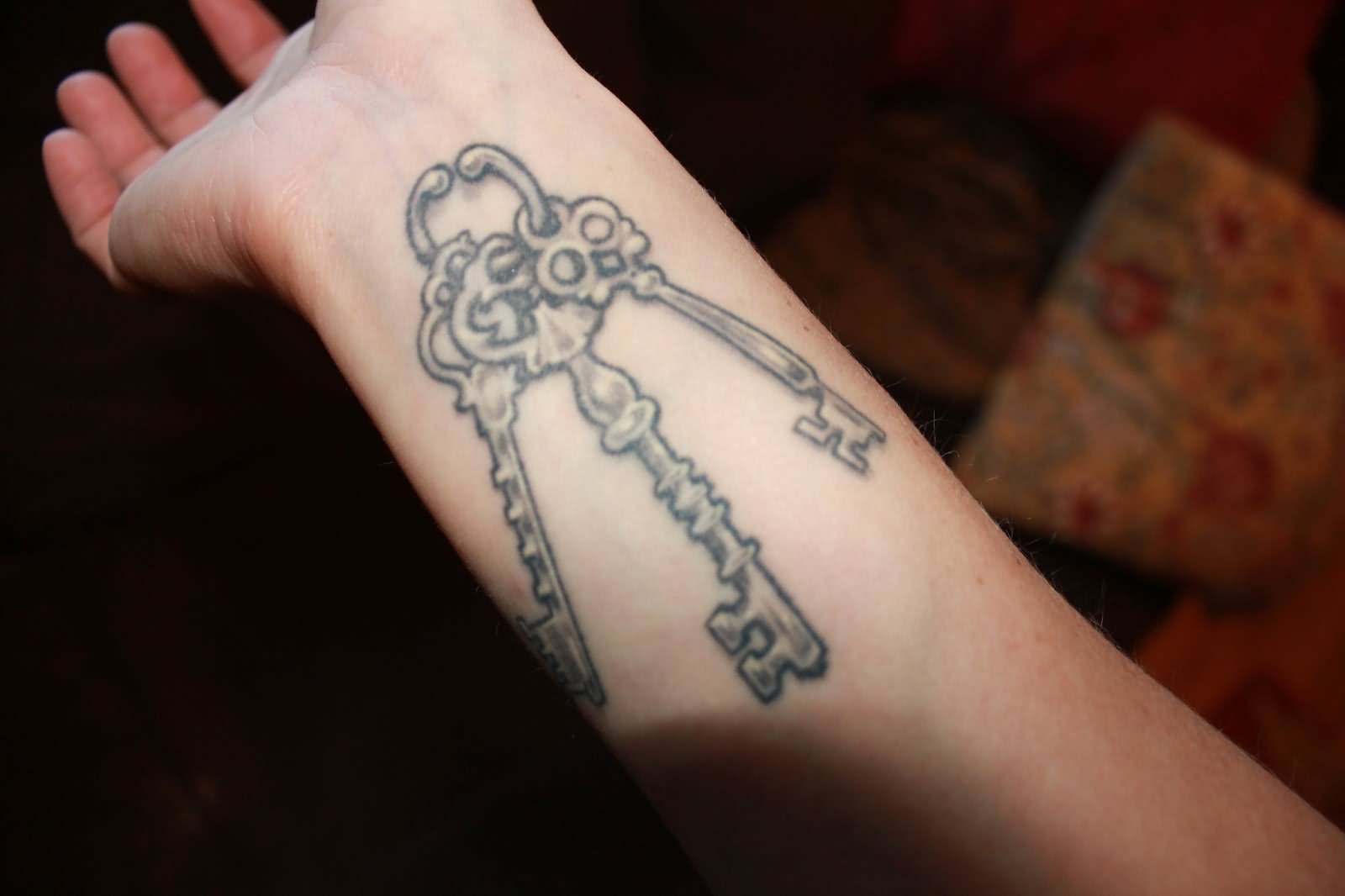 Grey Ink Skeleton Key Tattoo On Right Wrist