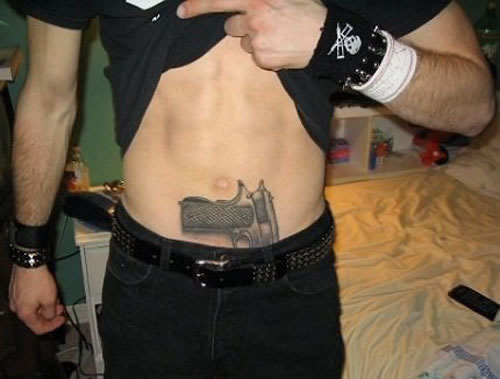 Guy Showing His Revolver Tattoo On Hip