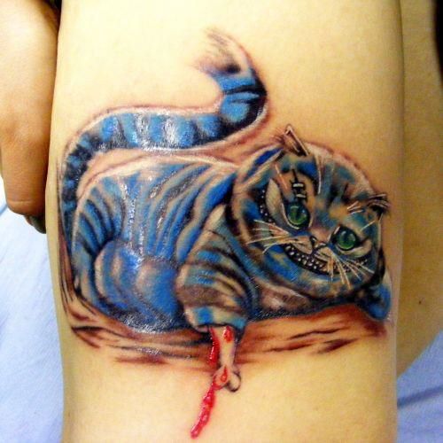 Left Bicep Blue Ink Cheshire Cat Tattoo