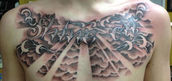 Shine On Lettering With Clouds Tattoo On Man Chest