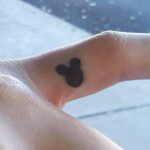 Small Black Mickey Mouse Tattoo On Finger