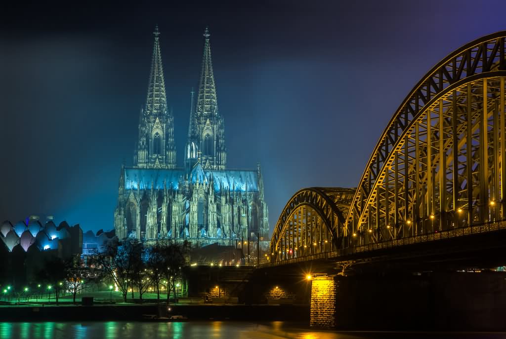 The Cologne Cathedral And Hohenzollern Bridge In Cologne At Night