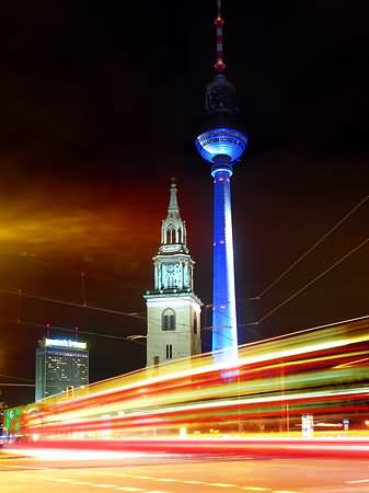 The Fernsehturm Tower And St. Mary Cathedral At Night With Motion Lights