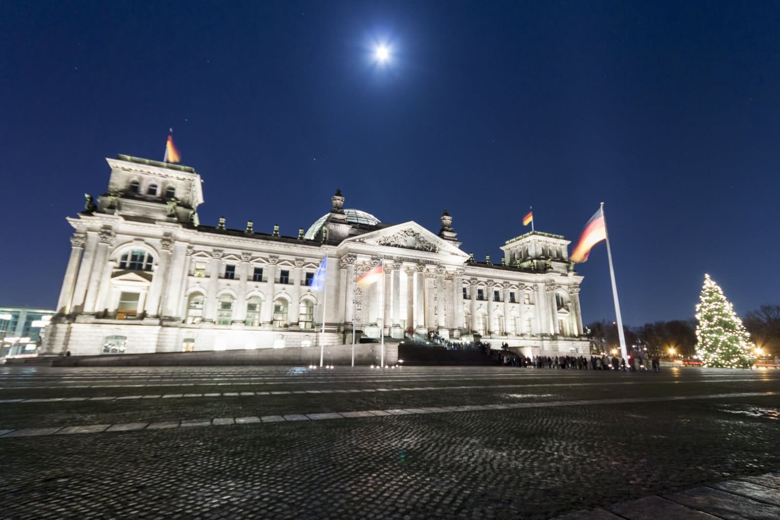 The Reichstag Building In Berlin, Germany By Night With Full Moon
