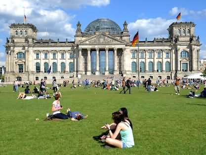 Visitors Enjoying Sunny Day In Park Front Of The Reichstag Building