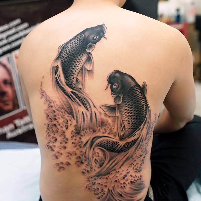 Black Ink Fishes Tattoo On Back