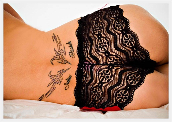 Black Outline Tribal Design Tattoo On Girl Lower Back