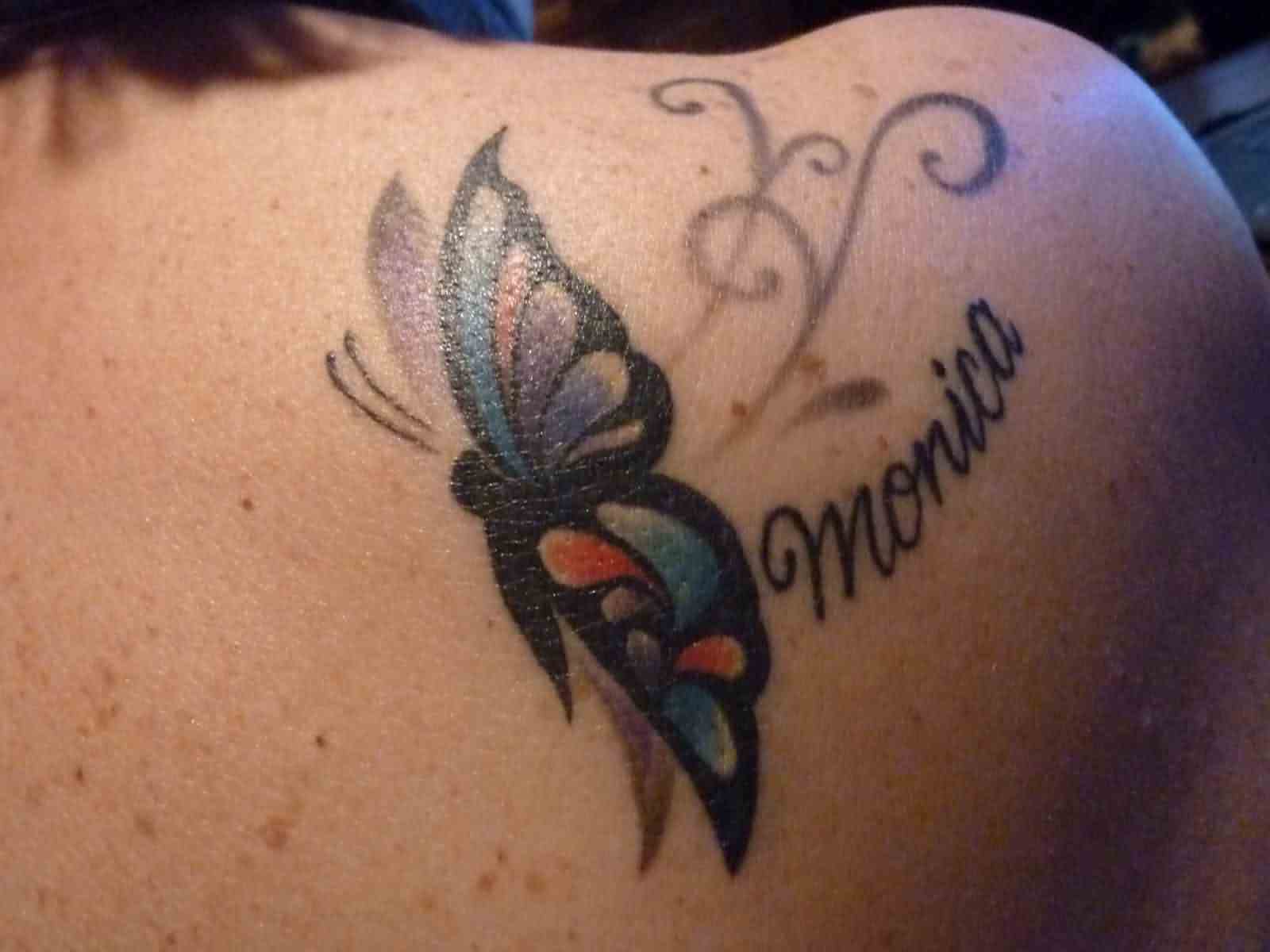 Colorful Butterfly With Monica Name Tattoo On Right Back Shoulder