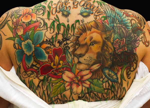 Colorful Flowers With Lion Head Tattoo On Upper Back