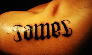 James Name Tattoo On Left Upper Shoulder