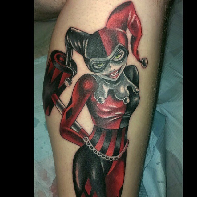 Red And Black Ink Harley Quinn Tattoo On Leg