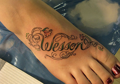 Wesson Name With Flowers Tattoo On Right Foot