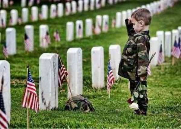 A Little Kid Saluting Tombstone Of His Father On The Memorial Day