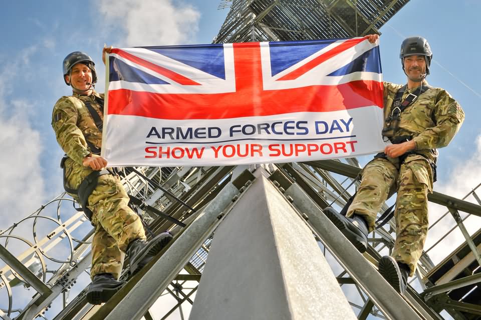 Airmen Holding Up The Armed Forces Day Flag