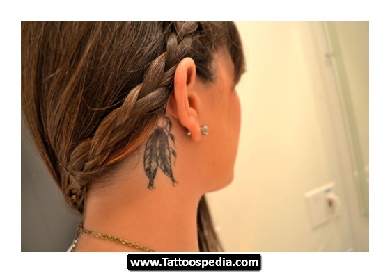 Black And Grey Feathers Tattoo On Girl Right Behind The Ear