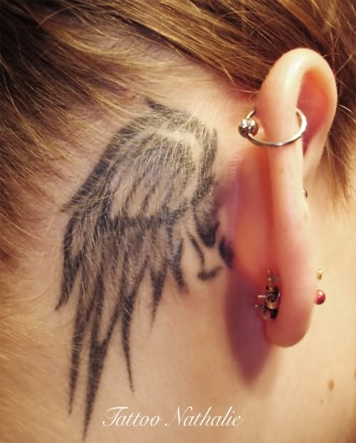 Black And Grey Wing Tattoo On Girl Right Behind The Ear