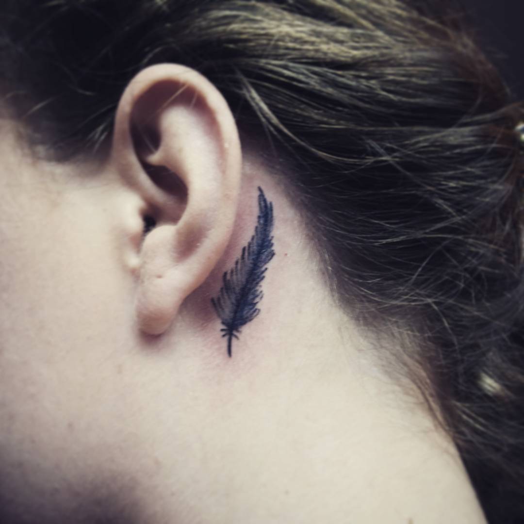 Black Feather Tattoo On Left Behind The Ear