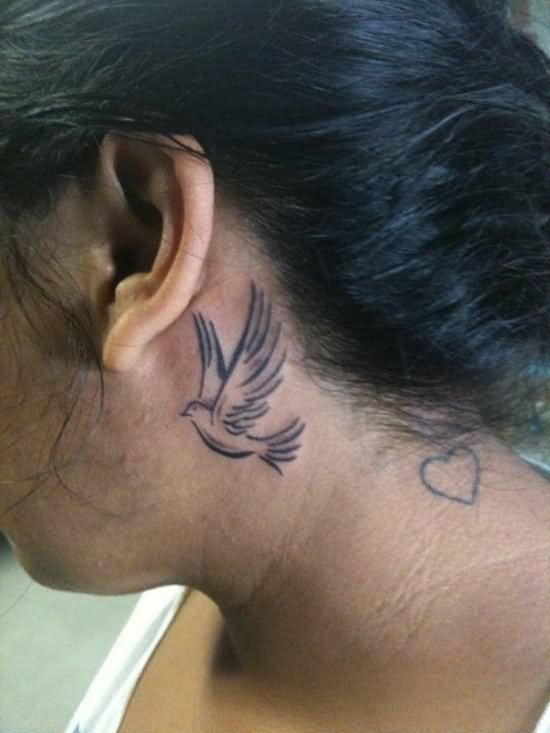 Black Flying Bird Tattoo On Left Behind The Ear
