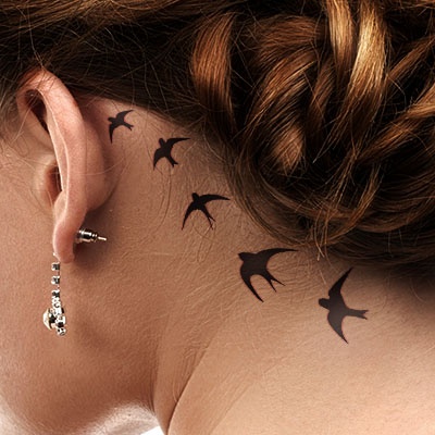 Black Flying Birds Tattoo On Girl Left Behind The Ear