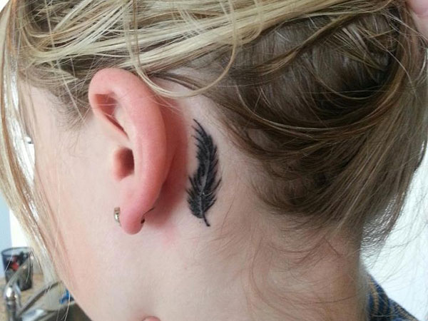 Black Ink Feather Tattoo On Girl Left Behind The Ear