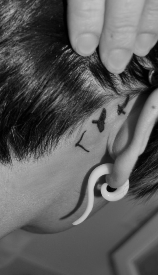 Black Ink Flying Birds Tattoo On Right Behind The Ear
