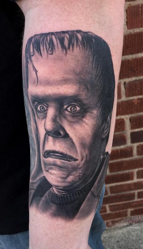 Black Ink Frankenstein Head Tattoo On Left Arm By Bob Tyrrell