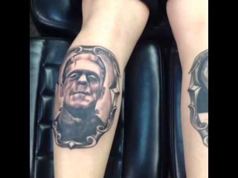 Black Ink Frankenstein In Frame Tattoo Design For Leg Calf