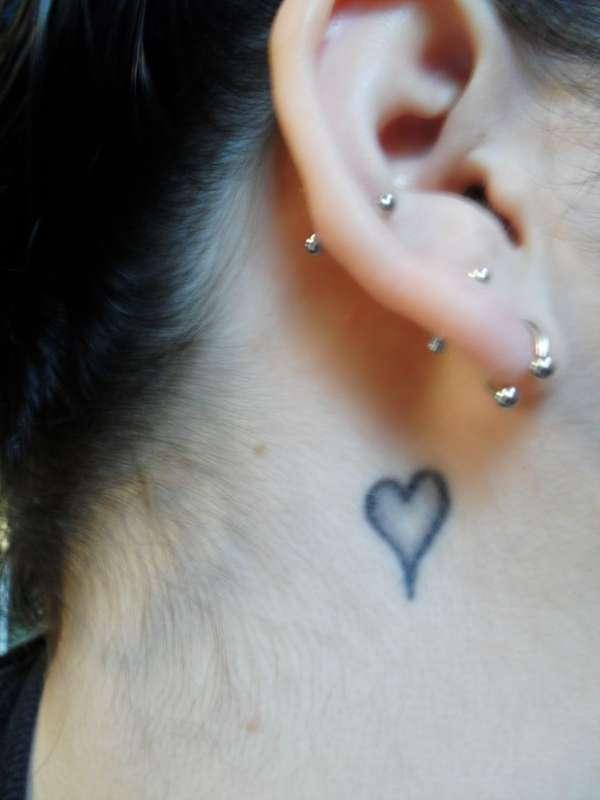 Black Ink Heart Tattoo On Girl Right Behind The Ear