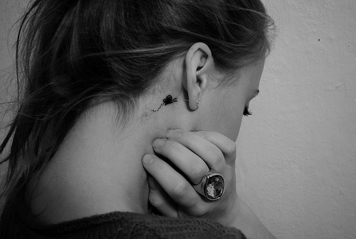 Black Little Butterfly Tattoo On Girl Right Behind The Ear