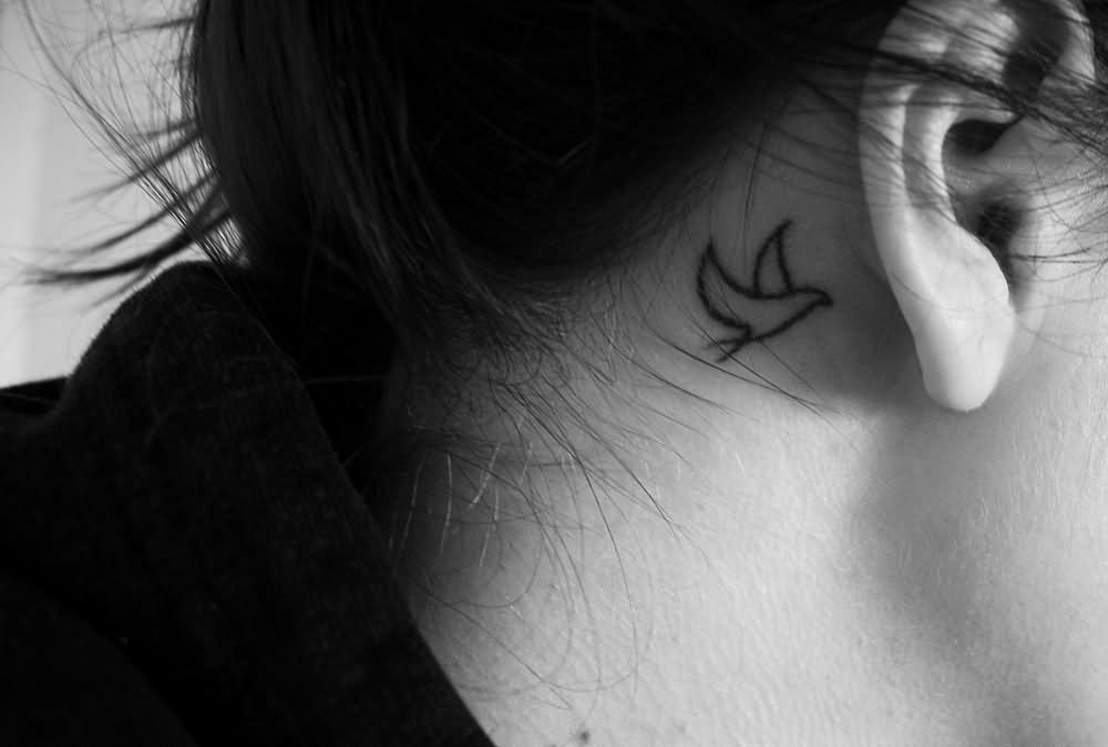 Black Outline Flying Bird Tattoo On Right Behind The Ear