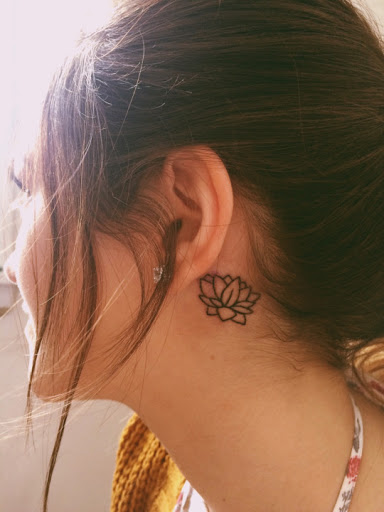 Black Outline Lotus Flower Tattoo On Girl Left Behind The Ear