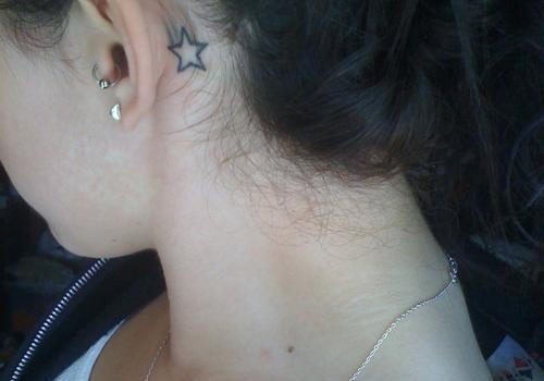 Black Outline Star Tattoo On Left Behind The Ear
