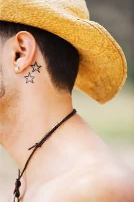 Black Outline Two Star Tattoo On Man Left Behind The Ear