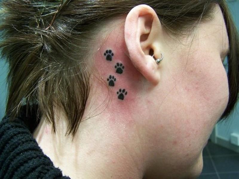 Black Paw Prints Tattoo On Right Behind The Ear