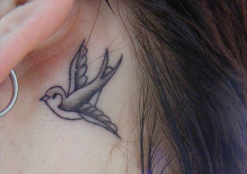 Cute Black Ink Bird Tattoo On Left Behind The Ear
